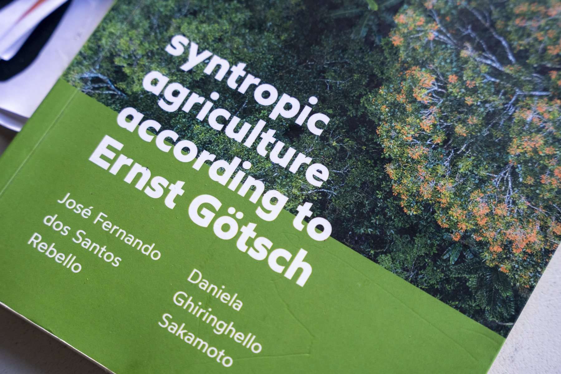 Un libro de agricultura sintrópica abierto sobre la mesa.